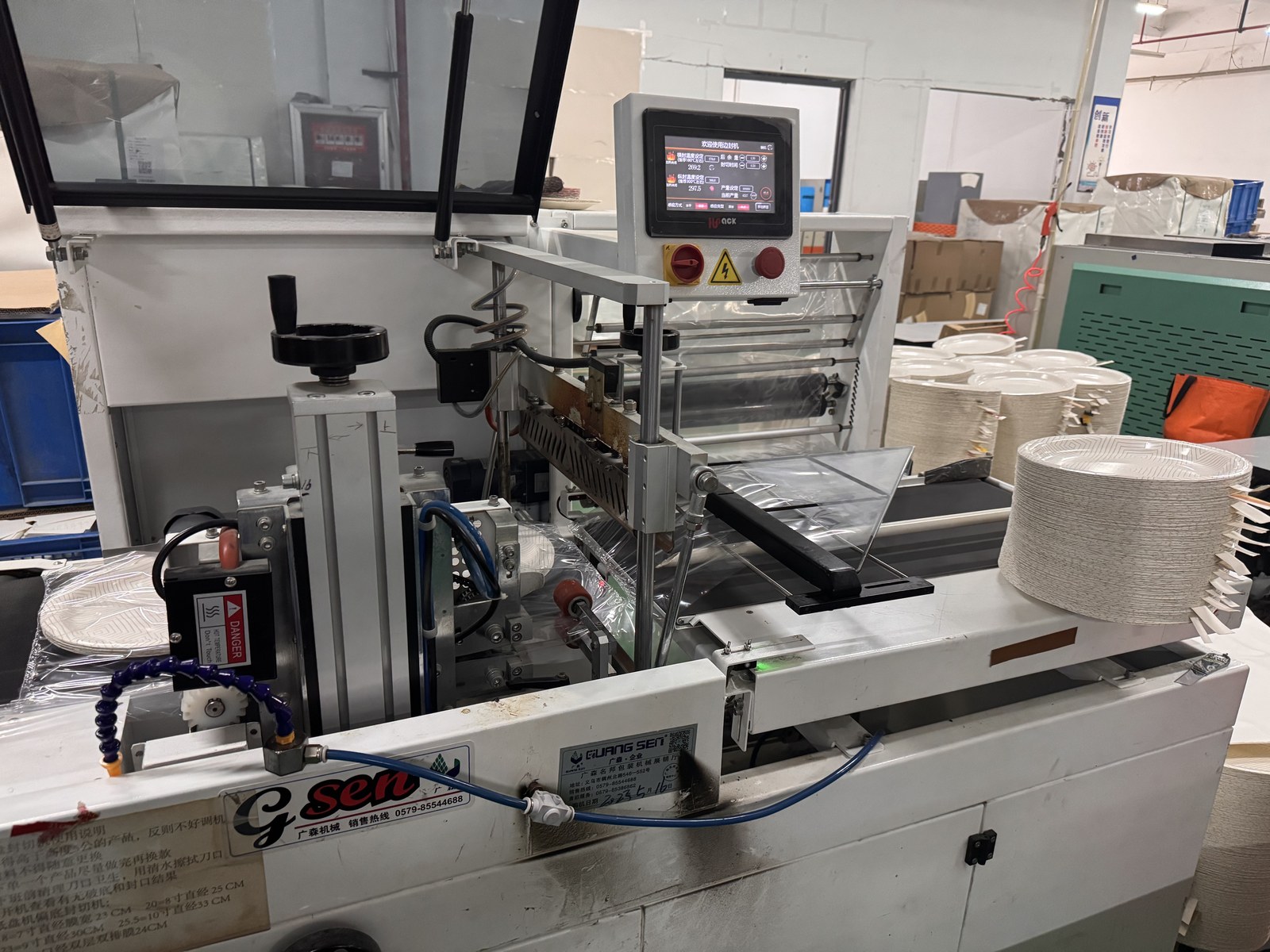 Paper product forming and packing equipment in a factory workshop